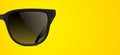 Stylish black sunglasses on a yellow background Royalty Free Stock Photo