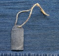 Stylish blank price tag on a rope on the background of denim for Royalty Free Stock Photo