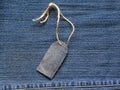 Stylish blank price tag on a rope on the background of denim for Royalty Free Stock Photo