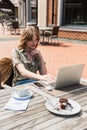 Stylish blogger using laptop near blurred