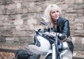 Stylish blond woman posing with motorcycle. Royalty Free Stock Photo