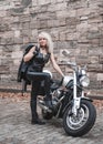 Stylish blond woman posing with motorcycle. Royalty Free Stock Photo