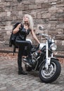 Stylish blond woman posing with motorcycle. Royalty Free Stock Photo