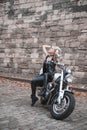 Stylish blond woman posing with motorcycle. Royalty Free Stock Photo