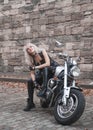 Stylish blond woman posing with motorcycle. Royalty Free Stock Photo