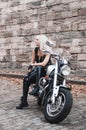 Stylish blond woman posing with motorcycle. Royalty Free Stock Photo