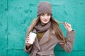 Stylish blonde woman in trendy urban outwear posing cold weather against grunge metal green painted background. Royalty Free Stock Photo