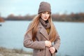 Stylish blonde woman in trendy urban outwear posing cold weather on the river bank. Vintage filter film saturated color. Fall mood Royalty Free Stock Photo