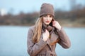 Stylish blonde woman in trendy urban outwear posing cold weather on the river bank. Vintage filter film saturated color. Fall mood Royalty Free Stock Photo