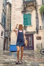 Stylish blonde in summer texas dress posing in front of old European buildings. Lifestyle, fashion, holiday concept