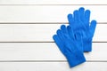 Stylish blue gloves on white wooden background, flat lay. Space for text Royalty Free Stock Photo