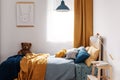 Stylish blue and orange kid`s bedroom design in bright apartment