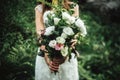 Stylish boho bride holding rustic bouquet of amazing flowers and herbs on background of rocks in mountains Royalty Free Stock Photo