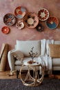 The stylish boho composition at living room interior with design beige sofa, coffee table, table, wicker baskets and personal Royalty Free Stock Photo