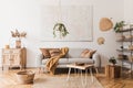 Modern boho interior of living room at cozy apartment with gray sofa. Royalty Free Stock Photo