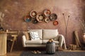 The stylish boho compostion at living room interior with design beige sofa, coffee table, table, wicker baskets and personal Royalty Free Stock Photo