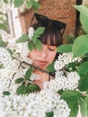 Stylish boho girl taking selfie with white flowers on green branches of bird-cherry tree. Girl portrait with beautiful bird cherry Royalty Free Stock Photo