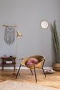 Stylish boho interior of bedroom with design furnitures, honey yellow armchair, macrame,lamp, plant and elegant accessories.