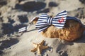 Stylish bow tie on stone at the beach. Men`s and women`s accessories on the sandy beach background Royalty Free Stock Photo