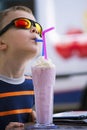 Stylish boy drinks a milkshake with ice cream Royalty Free Stock Photo