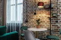 Stylish brick wall in retro style with a table standing next to it, illuminated by a lamp Royalty Free Stock Photo