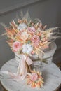 Stylish bridal bouquet of preserved flowers and lagurus with boutonniere. Dried and preserved flowers brides bouquet in