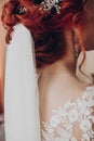 Stylish bride detail, luxury earring jewelry and red hair curl with veil, beautiful wedding dress. rustic wedding morning