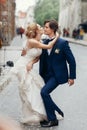 Stylish bride and groom dancing and having fun in city street. happy luxury wedding couple holding hands in light. romantic Royalty Free Stock Photo