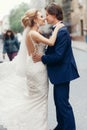 Stylish bride and groom dancing and having fun in city street. happy luxury wedding couple holding hands in light. romantic Royalty Free Stock Photo