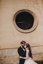 Stylish bride and groom gently hugging in european city street. Gorgeous wedding couple of newlyweds embracing near ancient Royalty Free Stock Photo