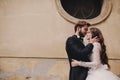 Stylish bride and groom gently hugging in european city street. Gorgeous wedding couple of newlyweds embracing near ancient Royalty Free Stock Photo