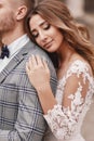 Stylish bride and groom gently hugging in european city street. Gorgeous wedding couple of newlyweds embracing near Royalty Free Stock Photo