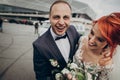 Stylish bride and groom hugging and laughing,having fun near retro car with boho bouquet. luxury wedding couple newlyweds, happy Royalty Free Stock Photo