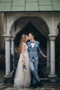 Stylish bride and groom kissing and embracing on background of old church. Romantic moment. Provence wedding. Beautiful sensual Royalty Free Stock Photo