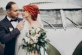 Stylish bride and groom sensually posing near retro car with boho bouquet. luxury wedding couple newlyweds embracing. space for Royalty Free Stock Photo