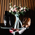 A stylish bride and groom shoes, wedding bouquet with flowers, ribbons and gold wedding rings in a box, a garter on the leg. Royalty Free Stock Photo