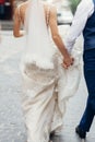 Stylish bride and groom walking in city street. happy luxury wedding couple holding hands in light and moving. romantic sensual Royalty Free Stock Photo