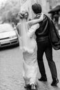 Stylish bride and groom walking in city street. happy luxury wedding couple holding hands in light and moving. romantic sensual Royalty Free Stock Photo