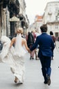 Stylish bride and groom walking in city street. happy luxury wedding couple holding hands in light and running. romantic sensual Royalty Free Stock Photo