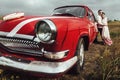 Stylish bride and happy groom near red retro car on the background of nature Royalty Free Stock Photo