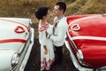 Stylish bride and happy groom near  two retro cars on the background of nature Royalty Free Stock Photo