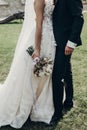 Stylish bride holding golden bouquet of roses with ribbons, stan Royalty Free Stock Photo