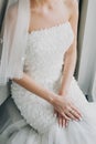 Stylish bride holding hands with pink and white nails manicure on modern dress, getting ready in hotel room. Morning preparation Royalty Free Stock Photo