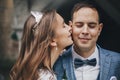 Stylish bride kissing happy groom in cheek on background of old church. Romantic moment. Provence wedding. Portrait of beautiful Royalty Free Stock Photo