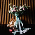 A stylish bride shoes wedding bouquet with flowers of roses, ribbons and gold wedding rings in a box, a garter on the leg. Wedding Royalty Free Stock Photo