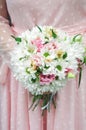 Stylish bride in a white dress holds an unusual wedding bouquet close-up. Delicate wedding bouquet of different flowers in the Royalty Free Stock Photo