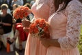 Stylish bridesmaids in pink lace dress holding amazing bouquets