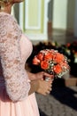 Stylish bridesmaids in pink lace dress holding amazing bouquets