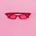 Stylish bright magenta sunglasses on pink