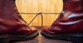 Stylish bright red boots with thick white laces tied together, close-up. April Fools` day, pranks and fun